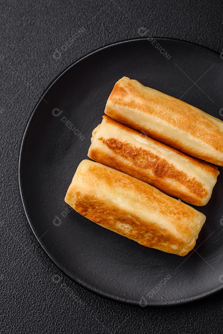 Deliciosas panquecas fritas caseiras frescas com brócolis e carne ou peixe com sal e especiarias sobre um fundo escuro de concreto