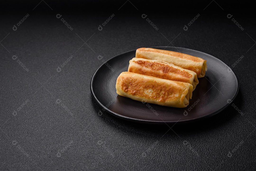 Deliciosas panquecas fritas caseiras frescas com brócolis e carne ou peixe com sal e especiarias sobre um fundo escuro de concreto