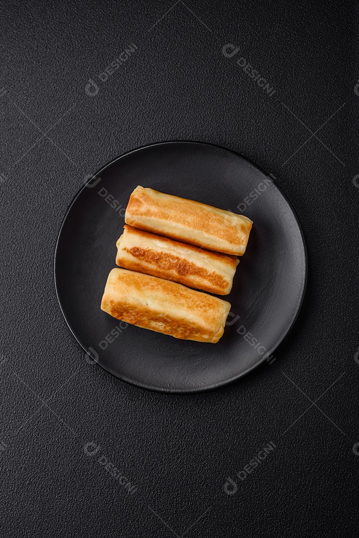 Deliciosas panquecas fritas caseiras frescas com brócolis e carne ou peixe com sal e especiarias sobre um fundo escuro de concreto