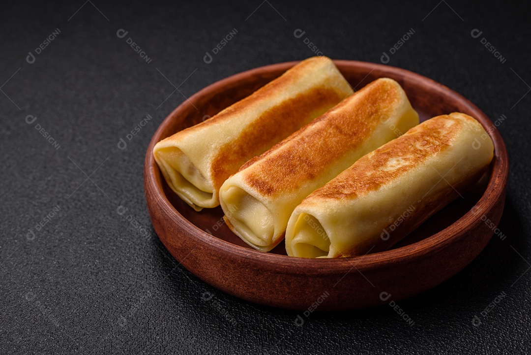 Deliciosas panquecas fritas caseiras frescas com brócolis e carne ou peixe com sal e especiarias sobre um fundo escuro de concreto