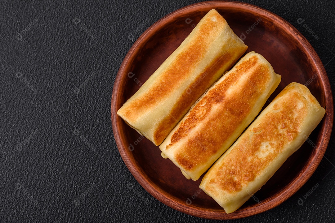 Deliciosas panquecas fritas caseiras frescas com brócolis e carne ou peixe com sal e especiarias sobre um fundo escuro de concreto