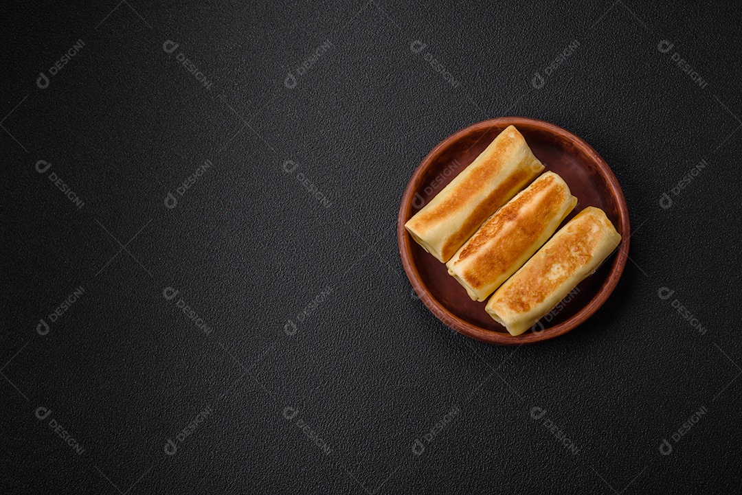 Deliciosas panquecas fritas caseiras frescas com brócolis e carne ou peixe com sal e especiarias sobre um fundo escuro de concreto