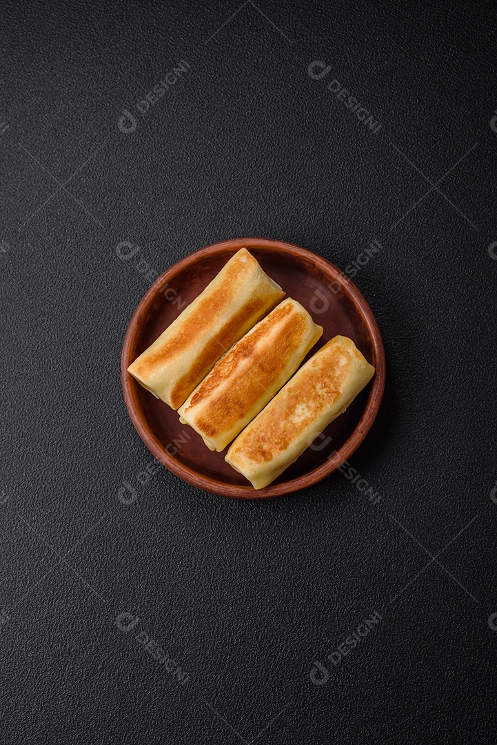 Deliciosas panquecas fritas caseiras frescas com brócolis e carne ou peixe com sal e especiarias sobre um fundo escuro de concreto