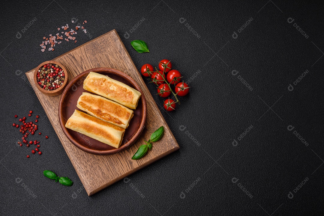 Deliciosas panquecas fritas caseiras frescas com brócolis e carne ou peixe com sal e especiarias sobre um fundo escuro de concreto