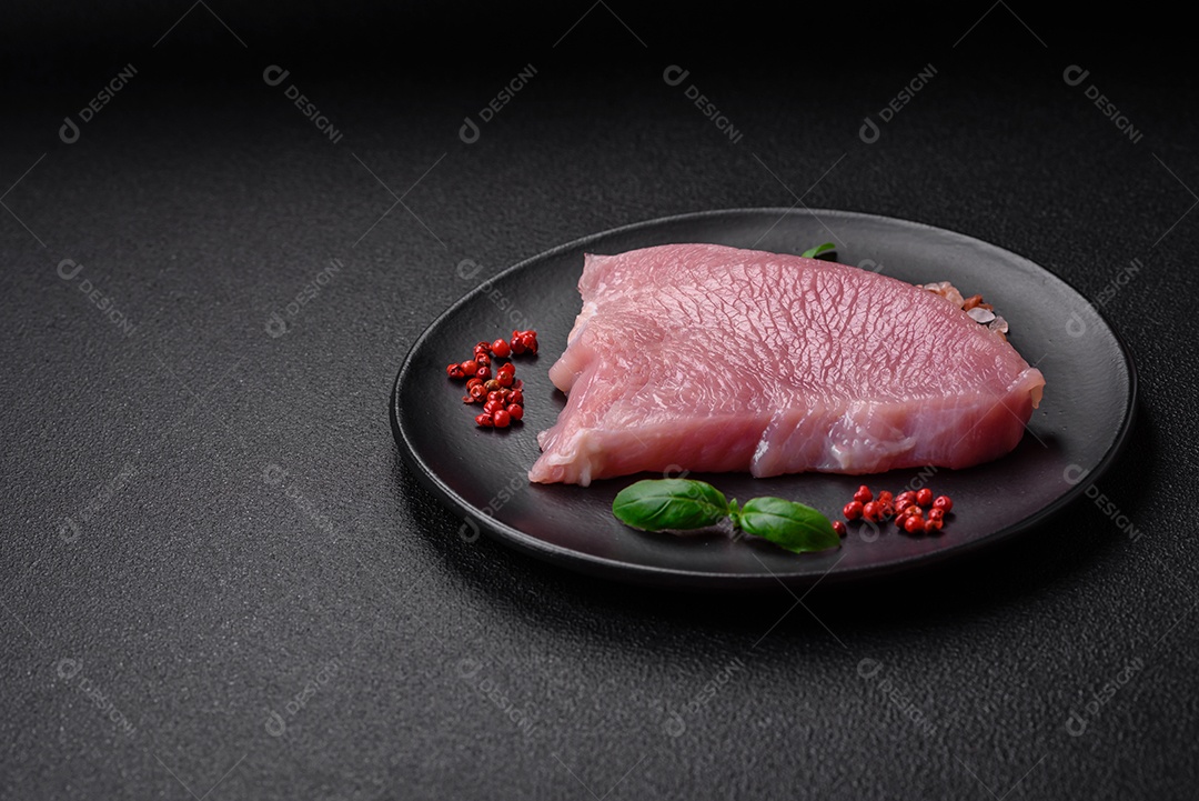 Bife de carne de porco fresca crua com sal, especiarias e ervas numa tábua de madeira