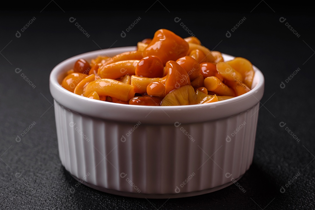 Delicioso prato de cozinha asiática com macarrão de arroz, pimentão, cogumelos e especiarias sobre fundo escuro de concreto