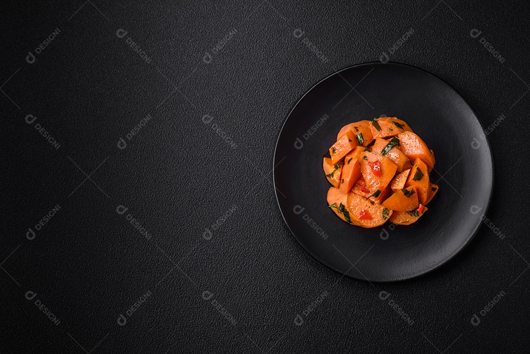 Deliciosa batata-doce cozida com cubos de sal, especiarias e ervas em uma placa cerâmica sobre um fundo escuro de concreto