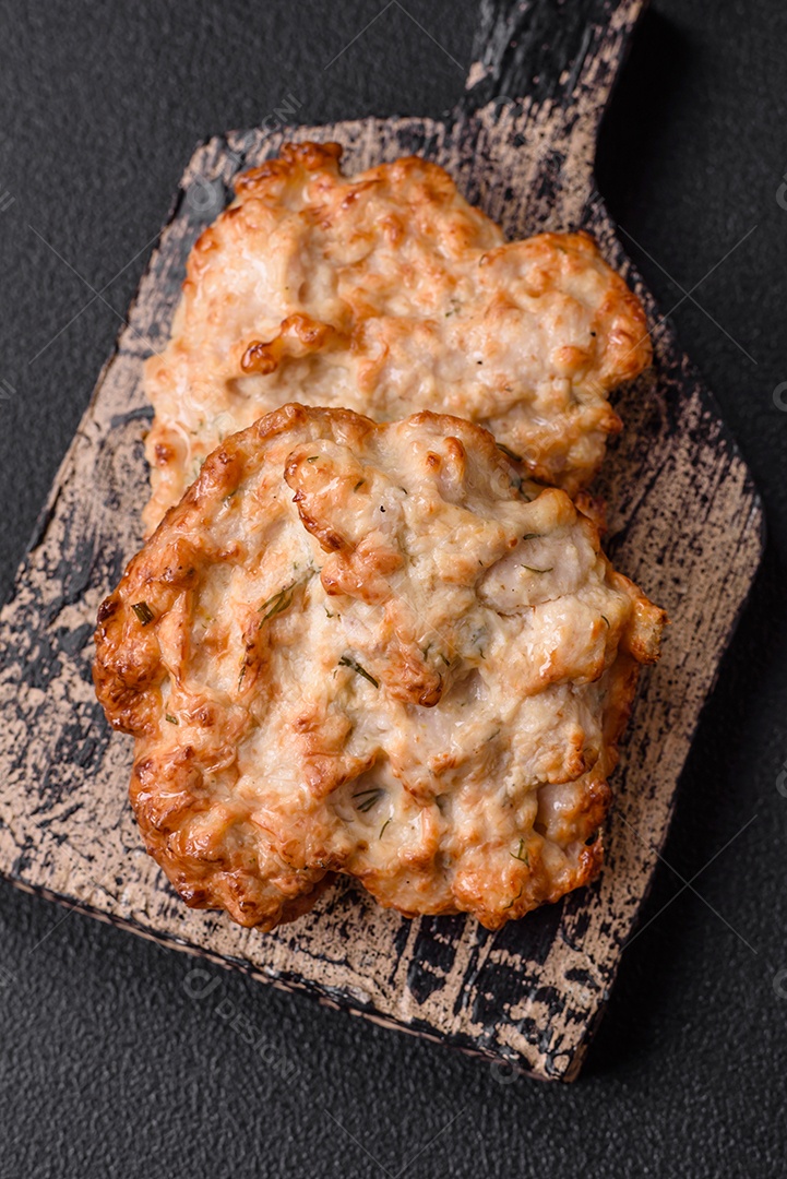 Deliciosa costeleta de frango frito ou carne de porco frita à milanesa com sal, especiarias e ervas sobre um fundo escuro de concreto
