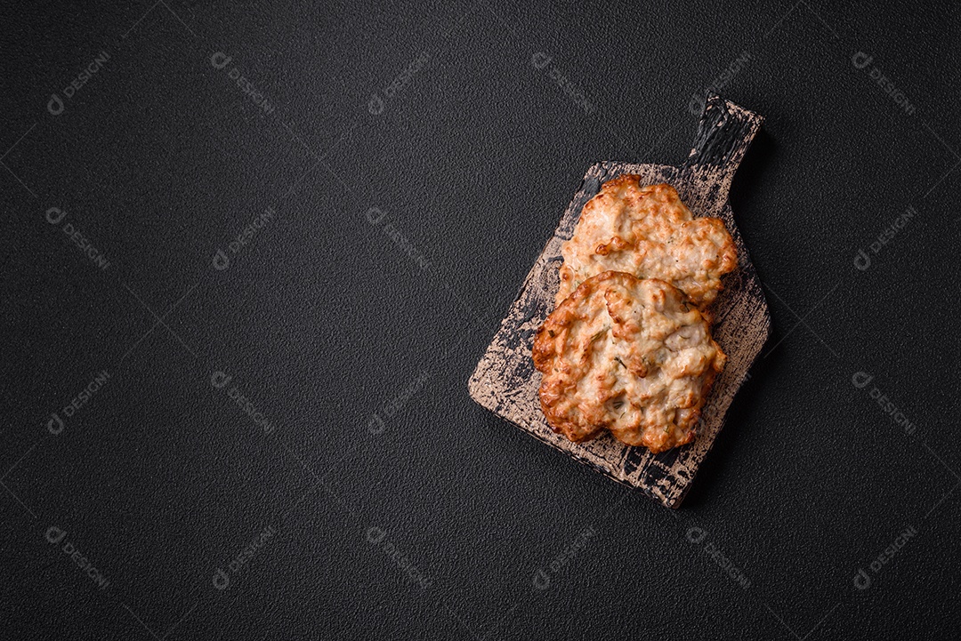 Deliciosa costeleta de frango frito ou carne de porco frita à milanesa com sal, especiarias e ervas sobre um fundo escuro de concreto