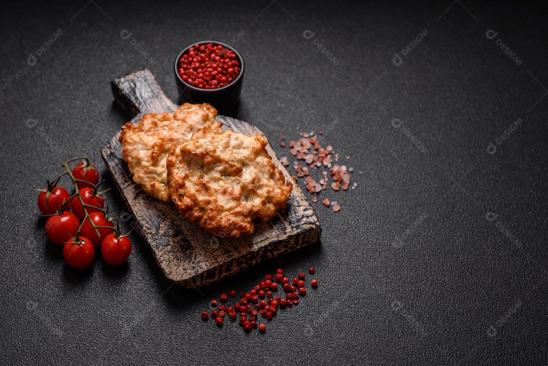 Deliciosa costeleta de frango frito ou carne de porco frita à milanesa com sal, especiarias e ervas sobre um fundo escuro de concreto