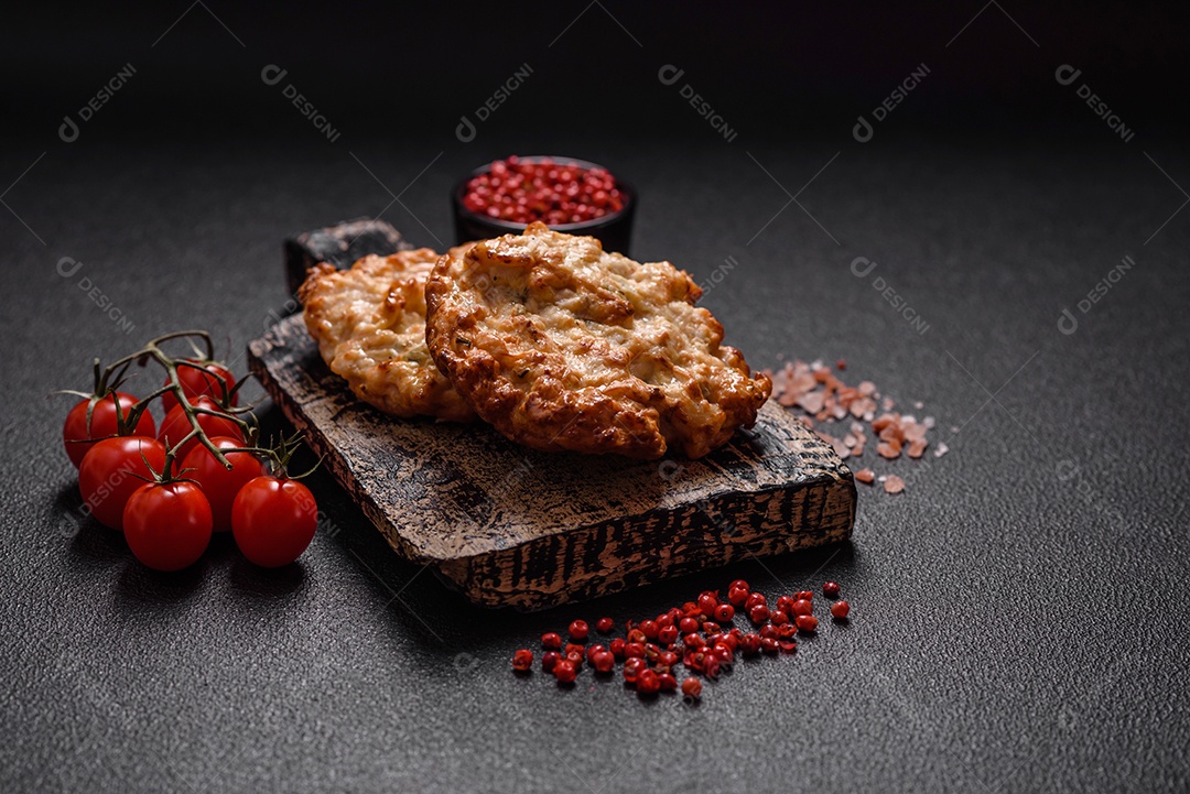 Deliciosa costeleta de frango frito ou carne de porco frita à milanesa com sal, especiarias e ervas sobre um fundo escuro de concreto