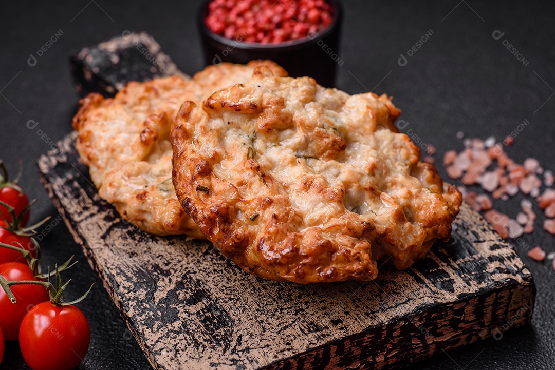 Deliciosa costeleta de frango frito ou carne de porco frita à milanesa com sal, especiarias e ervas sobre um fundo escuro de concreto