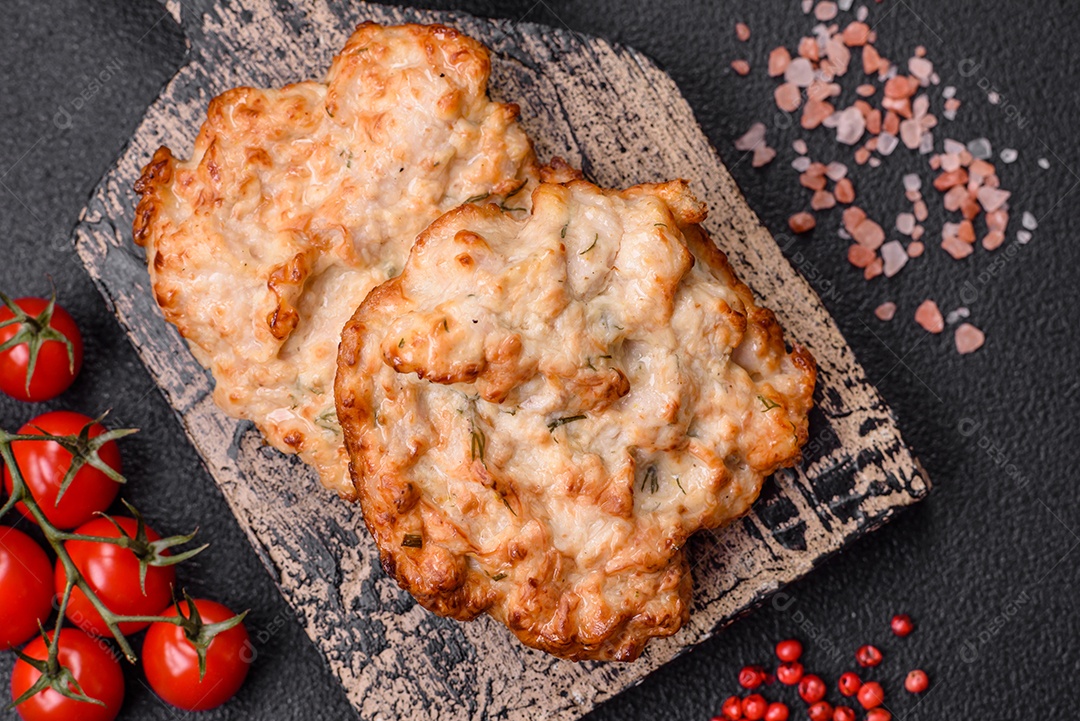 Deliciosa costeleta de frango frito ou carne de porco frita à milanesa com sal, especiarias e ervas sobre um fundo escuro de concreto