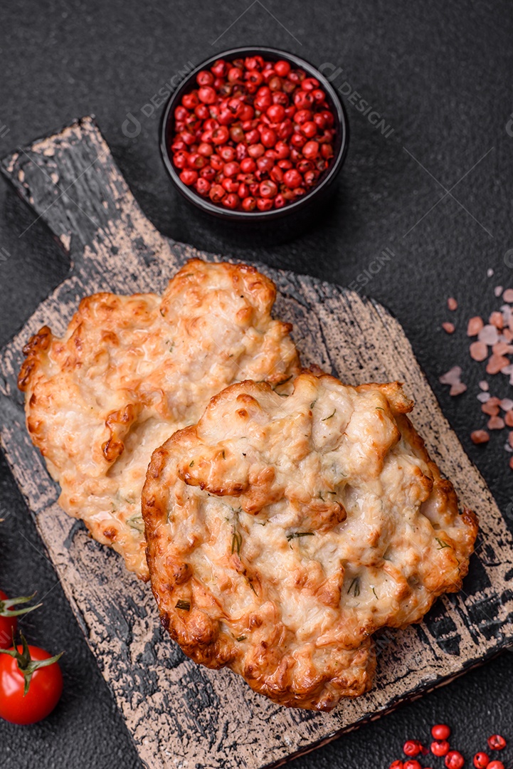 Deliciosa costeleta de frango frito ou carne de porco frita à milanesa com sal, especiarias e ervas sobre um fundo escuro de concreto