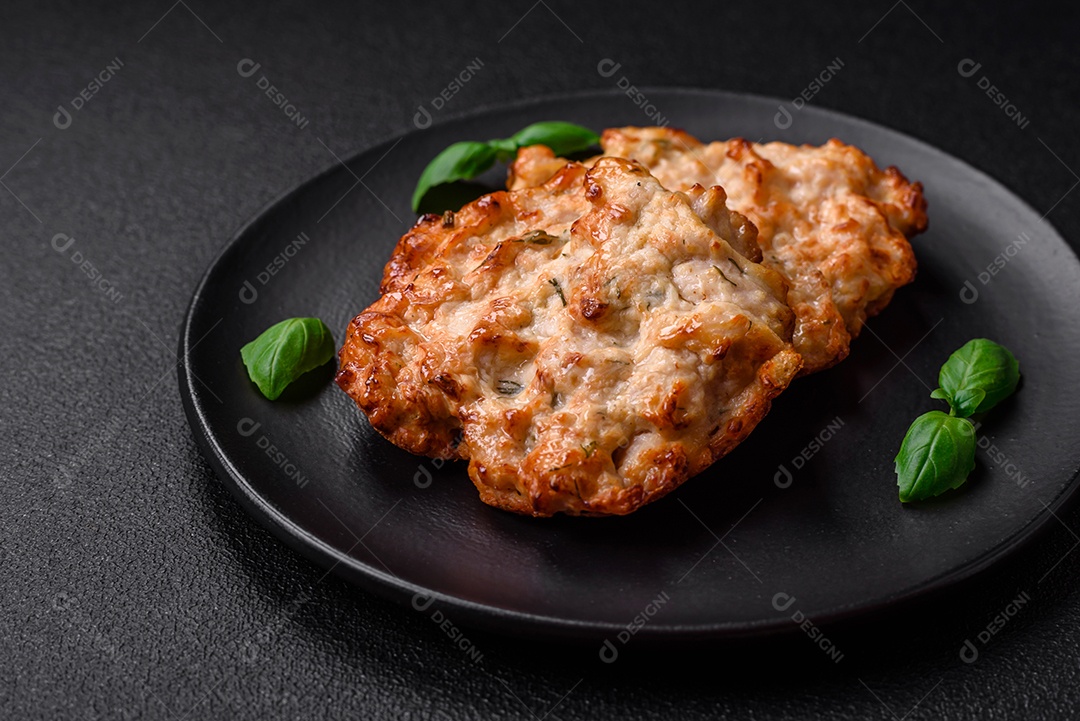 Deliciosa costeleta de frango frito ou carne de porco frita à milanesa com sal, especiarias e ervas sobre um fundo escuro de concreto