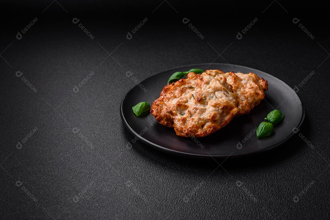 Deliciosa costeleta de frango frito ou carne de porco frita à milanesa com sal, especiarias e ervas sobre um fundo escuro de concreto
