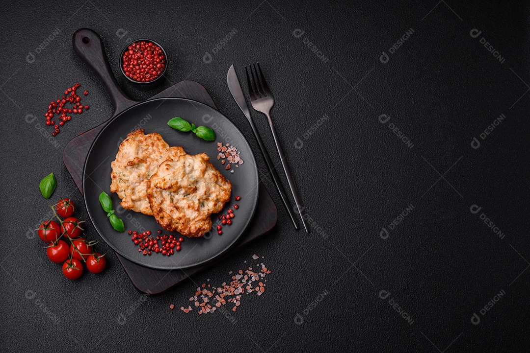 Deliciosa costeleta de frango frito ou carne de porco frita à milanesa com sal, especiarias e ervas sobre um fundo escuro de concreto