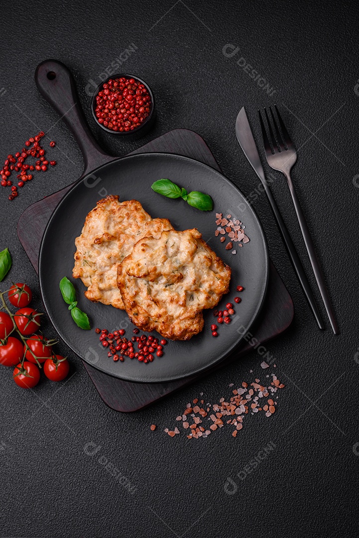 Deliciosa costeleta de frango frito ou carne de porco frita à milanesa com sal, especiarias e ervas sobre um fundo escuro de concreto