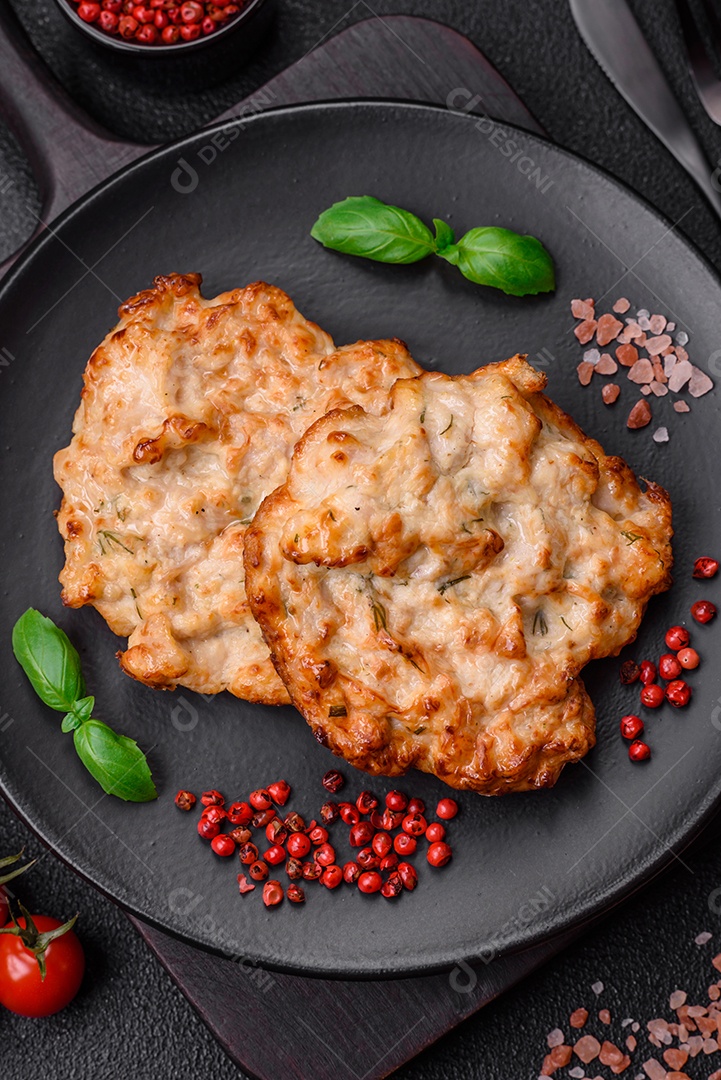 Deliciosa costeleta de frango frito ou carne de porco frita à milanesa com sal, especiarias e ervas sobre um fundo escuro de concreto