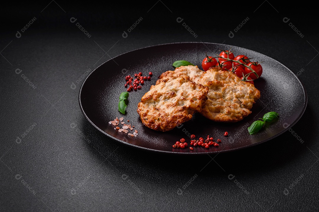Deliciosa costeleta de frango frito ou carne de porco frita à milanesa com sal, especiarias e ervas sobre um fundo escuro de concreto