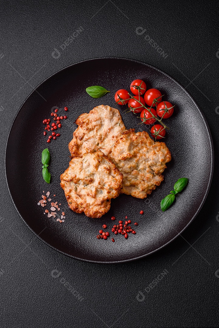 Deliciosa costeleta de frango frito ou carne de porco frita à milanesa com sal, especiarias e ervas sobre um fundo escuro de concreto