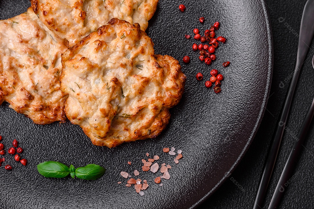 Deliciosa costeleta de frango frito ou carne de porco frita à milanesa com sal, especiarias e ervas sobre um fundo escuro de concreto