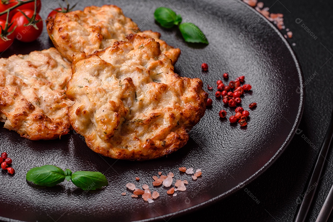 Deliciosa costeleta de frango frito ou carne de porco frita à milanesa com sal, especiarias e ervas sobre um fundo escuro de concreto