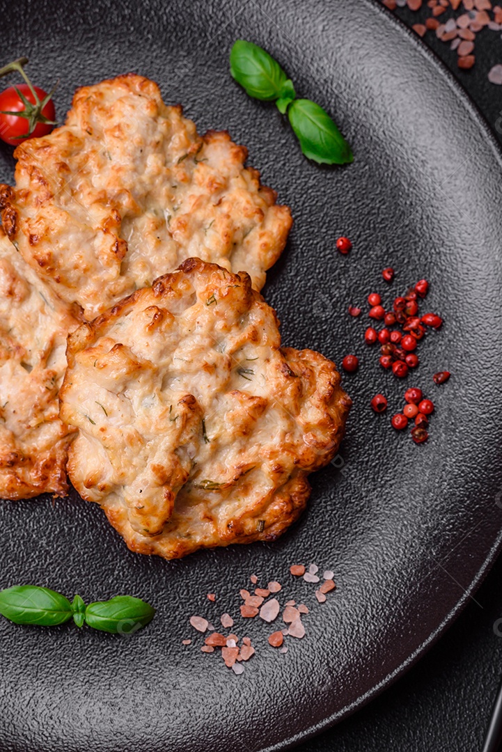 Deliciosa costeleta de frango frito ou carne de porco frita à milanesa com sal, especiarias e ervas sobre um fundo escuro de concreto
