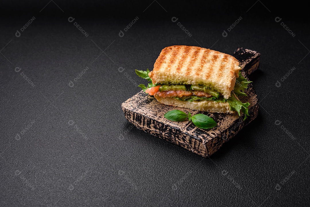 Delicioso pão trançado crocante com passas dentro e glacê branco fora sobre um fundo escuro de concreto