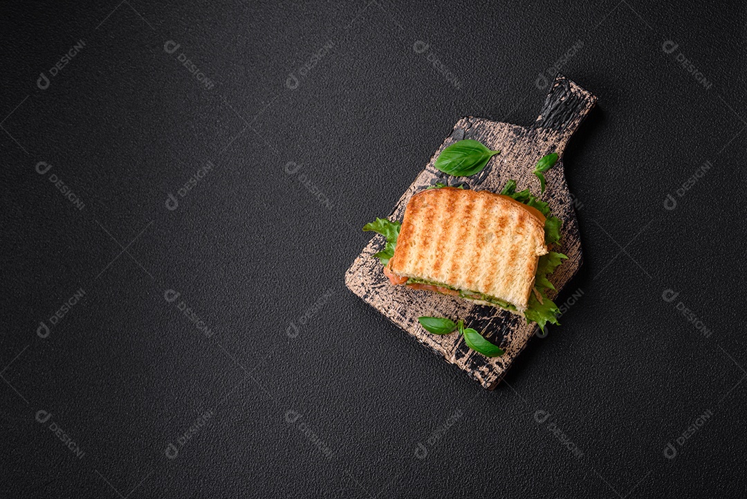 Delicioso pão trançado crocante com passas dentro e glacê branco fora sobre um fundo escuro de concreto