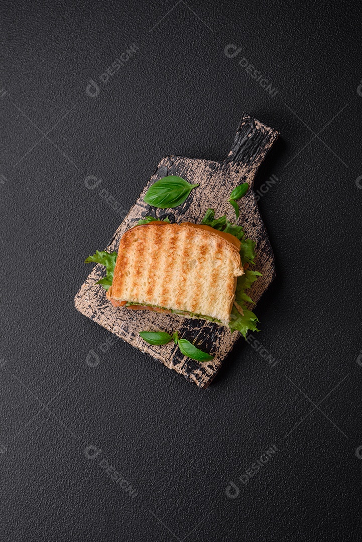 Delicioso pão trançado crocante com passas dentro e glacê branco fora sobre um fundo escuro de concreto
