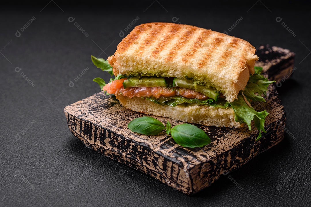 Delicioso pão trançado crocante com passas dentro e glacê branco fora sobre um fundo escuro de concreto
