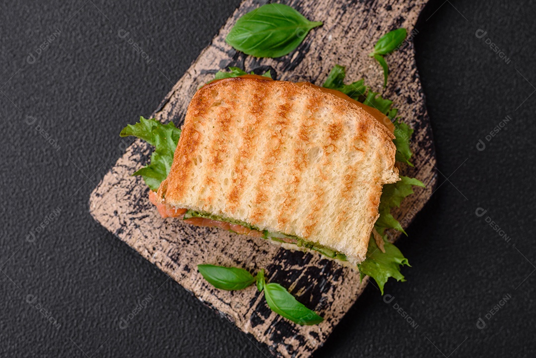 Delicioso pão trançado crocante com passas dentro e glacê branco fora sobre um fundo escuro de concreto