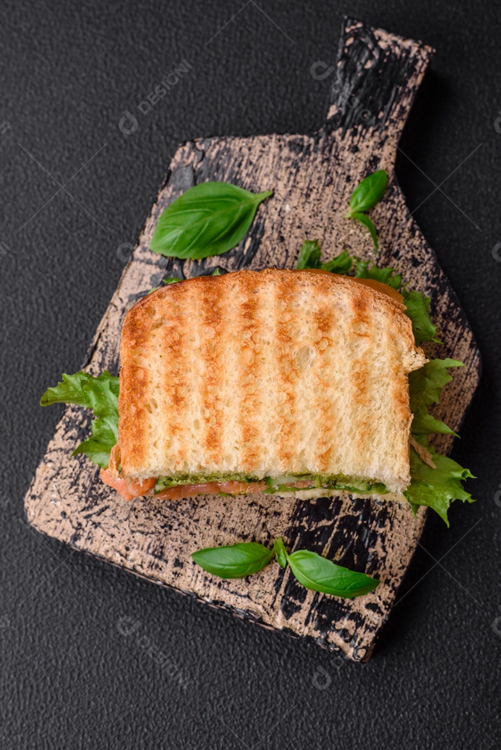 Delicioso pão trançado crocante com passas dentro e glacê branco fora sobre um fundo escuro de concreto