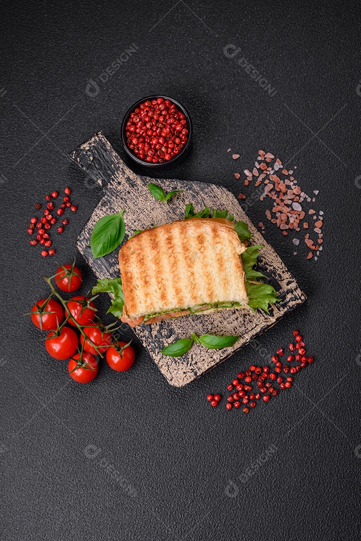 Delicioso pão trançado crocante com passas dentro e glacê branco fora sobre um fundo escuro de concreto