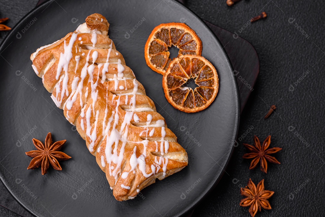 Delicioso pão trançado crocante com passas dentro e glacê branco fora sobre um fundo escuro de concreto