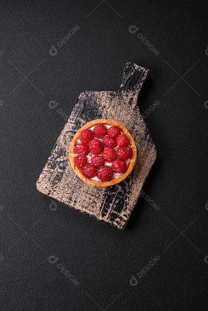 Deliciosa torta redonda doce e fresca com mirtilos maduros e creme sobre um fundo escuro de concreto