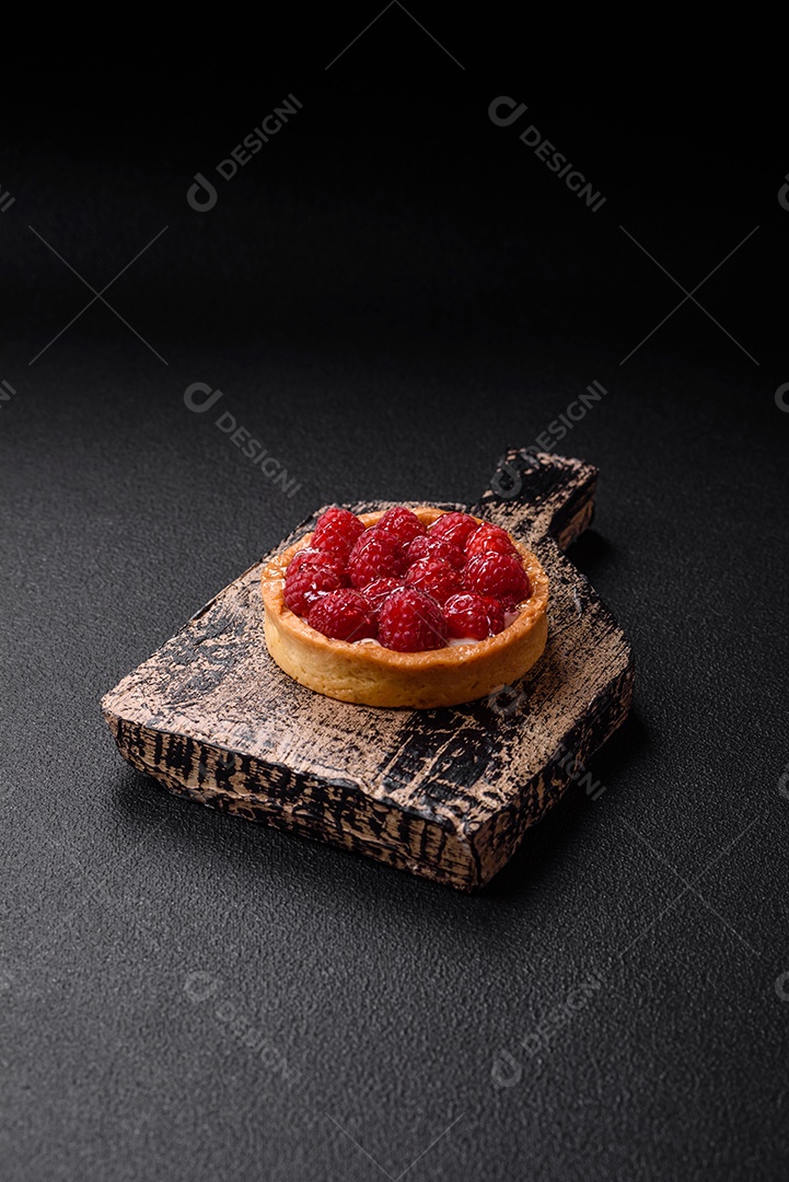 Deliciosa torta redonda doce e fresca com mirtilos maduros e creme sobre um fundo escuro de concreto