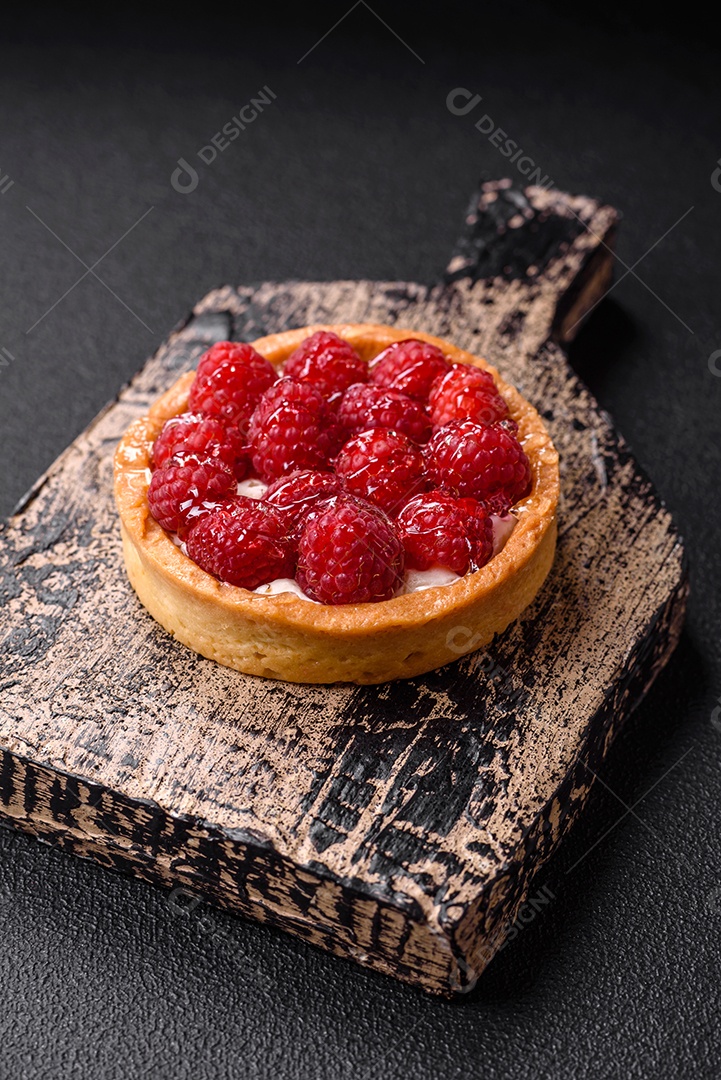 Deliciosa torta redonda doce e fresca com mirtilos maduros e creme sobre um fundo escuro de concreto