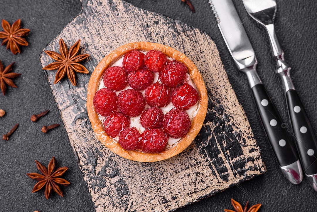 Deliciosa torta redonda doce e fresca com mirtilos maduros e creme sobre um fundo escuro de concreto