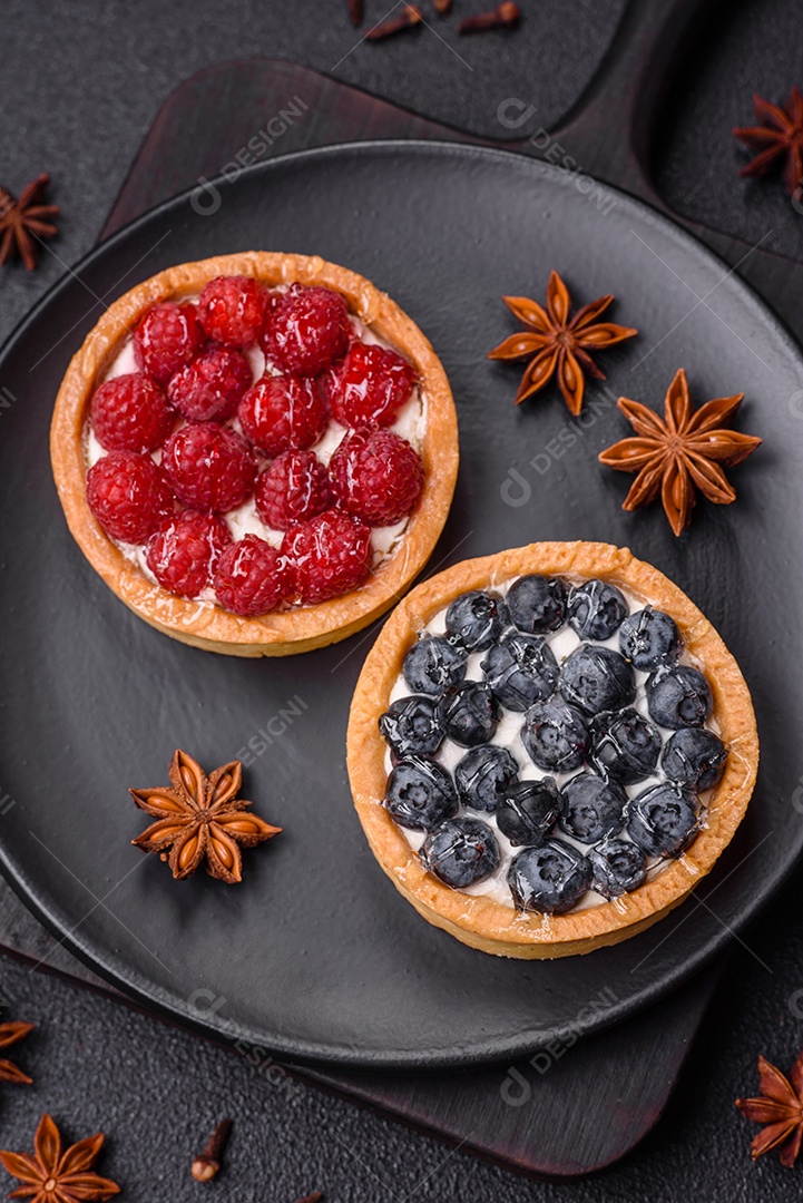 Deliciosa torta redonda doce e fresca com mirtilos maduros e creme sobre um fundo escuro de concreto