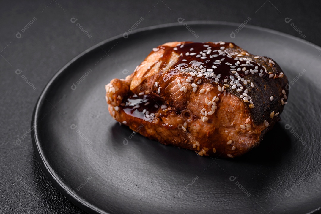 Delicioso filé de salmão grelhado com sal, especiarias, ervas e molho sobre fundo escuro de concreto