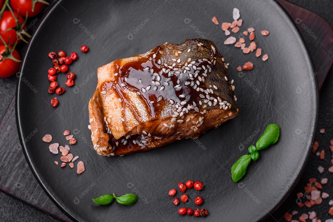 Delicioso filé de salmão grelhado com sal, especiarias, ervas e molho sobre fundo escuro de concreto
