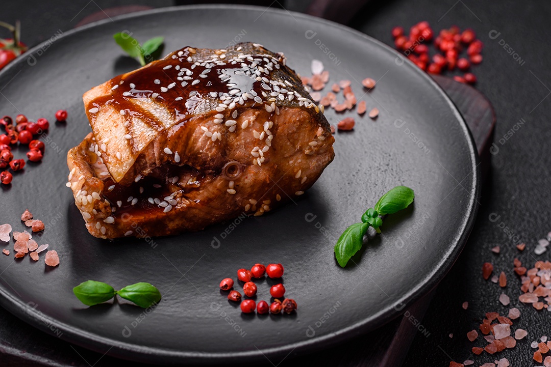 Delicioso filé de salmão grelhado com sal, especiarias, ervas e molho sobre fundo escuro de concreto