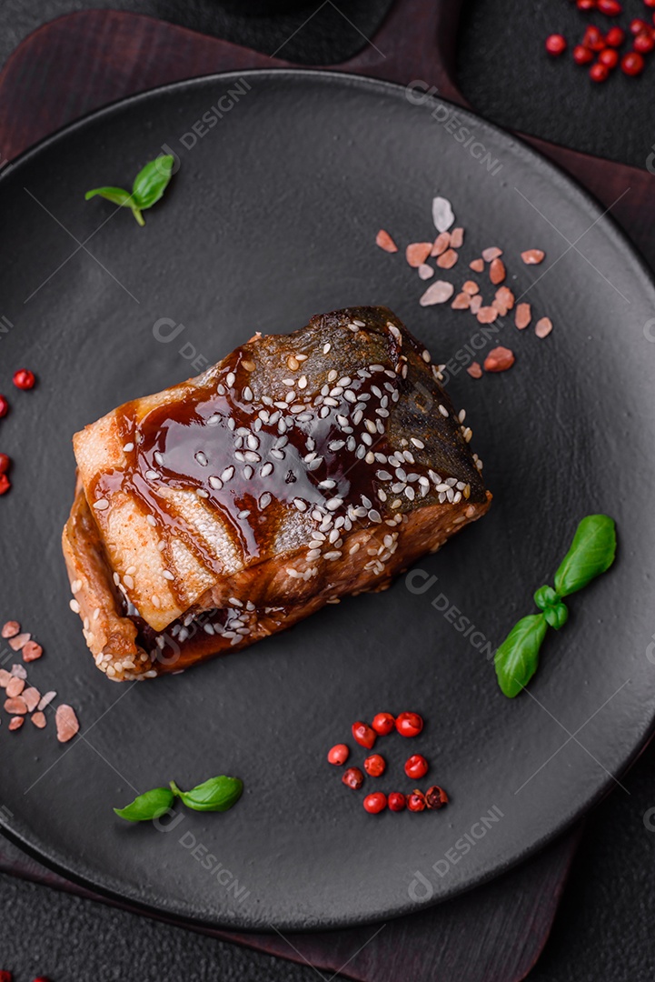 Delicioso filé de salmão grelhado com sal, especiarias, ervas e molho sobre fundo escuro de concreto