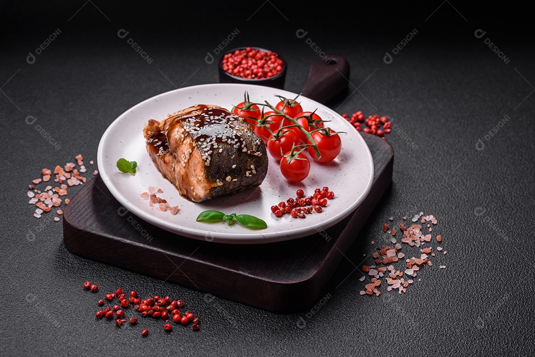 Delicioso filé de salmão grelhado com sal, especiarias, ervas e molho sobre fundo escuro de concreto