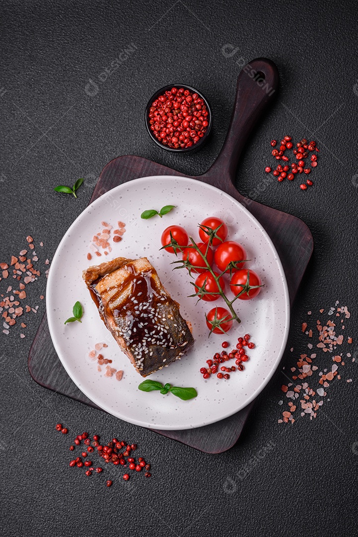 Delicioso filé de salmão grelhado com sal, especiarias, ervas e molho sobre fundo escuro de concreto