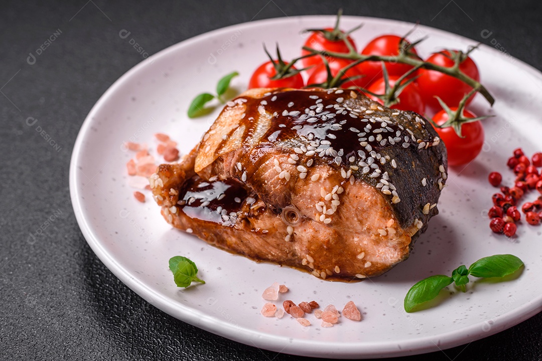 Delicioso filé de salmão grelhado com sal, especiarias, ervas e molho sobre fundo escuro de concreto