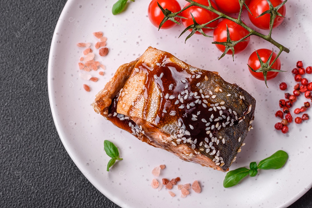 Delicioso filé de salmão grelhado com sal, especiarias, ervas e molho sobre fundo escuro de concreto