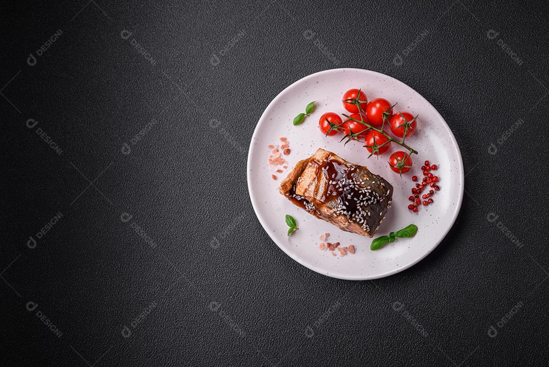 Delicioso filé de salmão grelhado com sal, especiarias, ervas e molho sobre fundo escuro de concreto